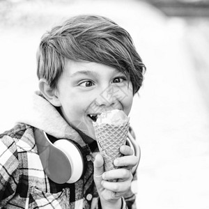 快乐的孩子吃冰淇淋可爱的男孩在华夫饼锥中拿着冰淇淋快图片