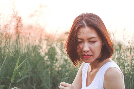 坐在草地上的女人背图片