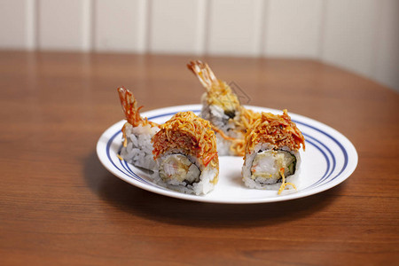 盘子上的松脆龙卷寿司片和虾天妇罗图片