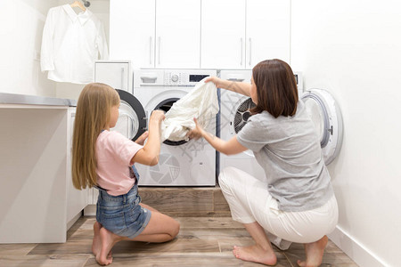 女孩用衣服在洗衣房图片