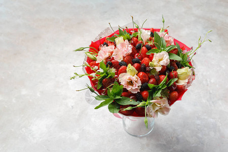 鲜花草莓樱桃和黑莓等独特花束放在大理石图片