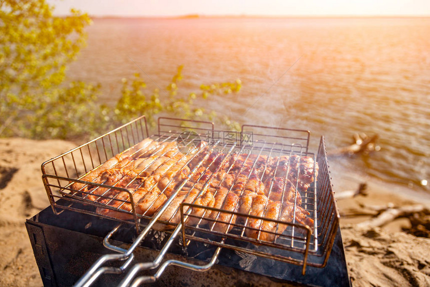 烤架上的鸡肉以大海和滩古食物摄影为背景图片
