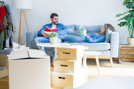 年轻夫妇在沙发上轻松放读书休息一图片