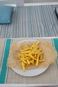 法式炸薯条在纸上和咖啡馆的盘子上图片