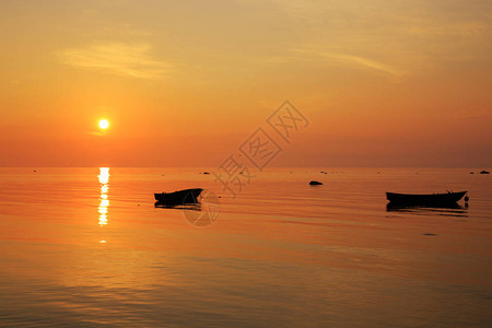 波罗的海上的清晨金色日出海上的渔船以日出和阳光为背景库尔泽图片