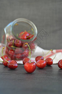 红色生樱桃和玻璃罐图片