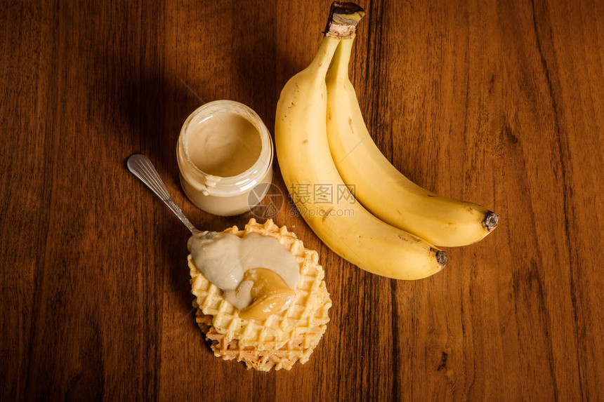 在塔希尼黄油罐头两只香蕉配着塔希尼的比利时华夫饼上勺子和图片
