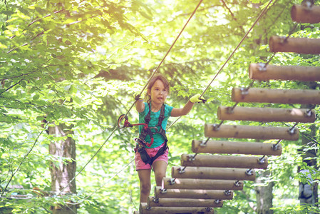 小女孩在冒险公园攀登男孩喜欢攀登绳图片
