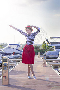 穿着草帽的漂亮女孩在游艇和船背景图片