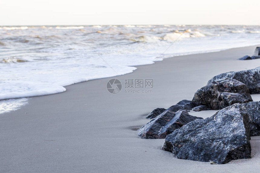 沙滩上的石头海浪图片