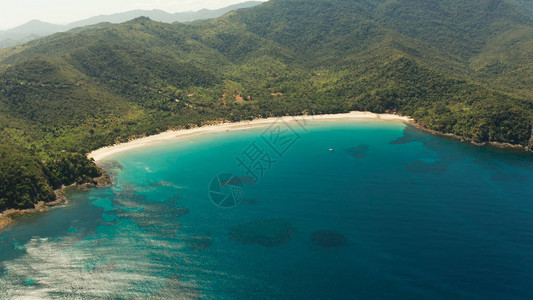 鸟瞰美丽的热带海滩Nagtabon在海湾与蓝色泻湖和绿松石水被热带雨林包围菲律宾巴拉望岛热带景观海景岛背景图片