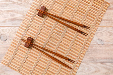 木竹背景上的两套寿司筷子顶视图图片
