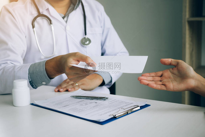 亚洲男医生在诊疗室交谈向病人提供图片