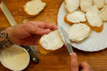 厨师在面包上撒了干酪男人的手在法国面包图片