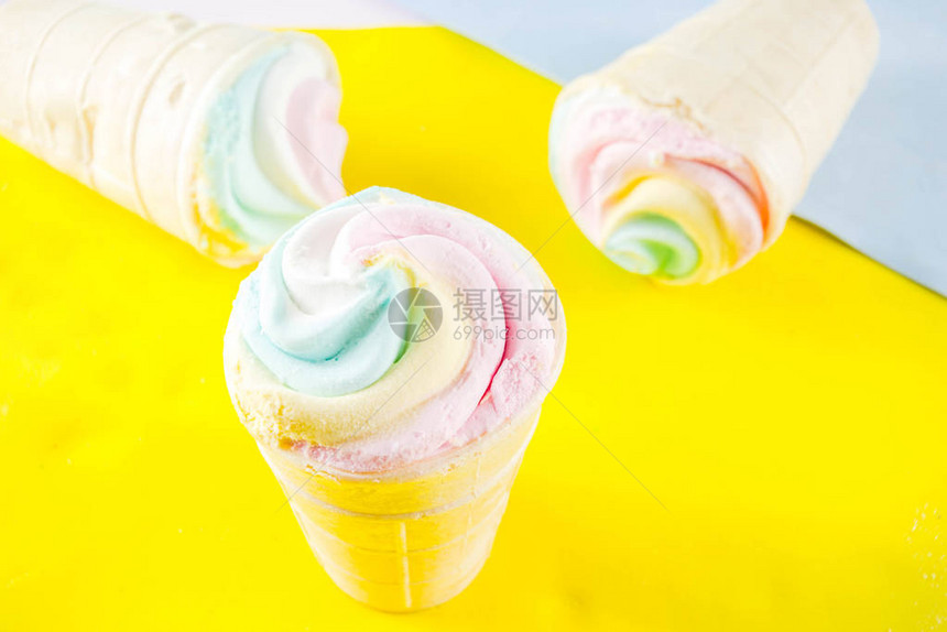 五彩柔和的独角兽彩虹冰淇淋明亮背景复制空间上的三个彩色冰图片