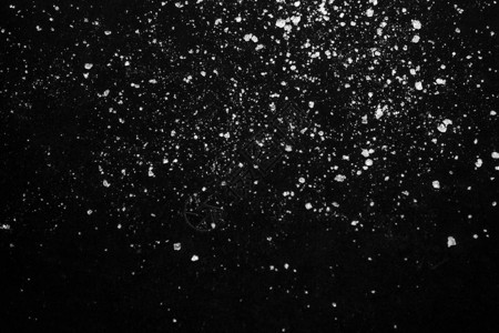 黑色背景上的白色结晶粉末糖粉图片