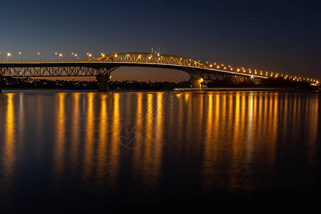 奥克兰港桥在夜间点燃长期接触以平滑水面图片