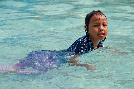 一个小女孩在游泳池里玩水感觉快乐图片