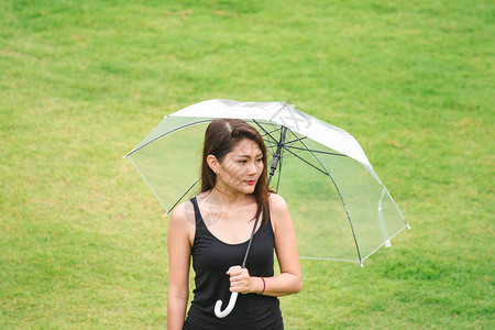 妇女们在草坪上撑着伞走图片