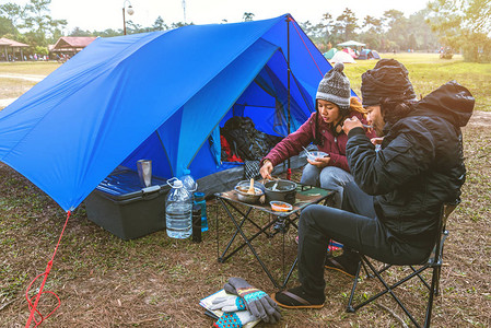 爱人男女亚洲人旅行在假期放松露营在山上露营坐着图片