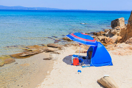 暑假旅行在孤单沙滩上露营蓝色沙图片