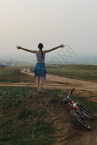 欧洲白人年轻女骑着自行车站在乡村山路上图片