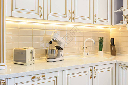 新古典风化的白色和金色木制厨房与豪华住宅图片