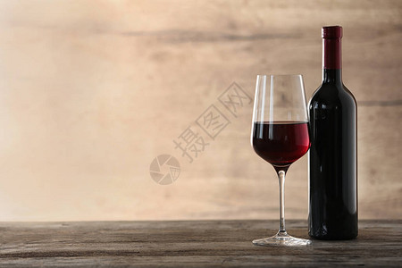 玻璃和一瓶红酒木制的桌子上文本空间图片
