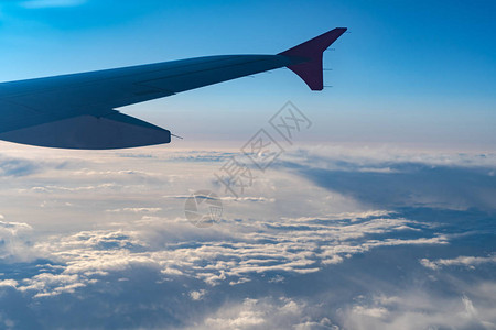 从飞机窗口看到飞机翼侧面的光影高清图片