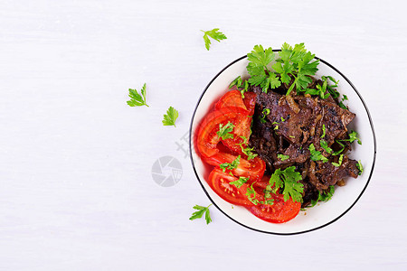 烤或牛肝配洋葱和西红柿沙拉中东美食顶视图图片