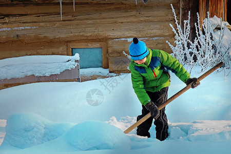 有铲子的男孩在下雪后扫清了道路图片