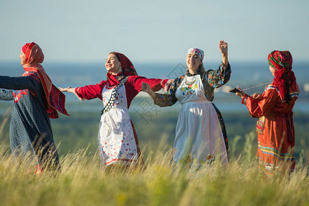 穿着传统俄罗斯服装在田野上跳舞的图片