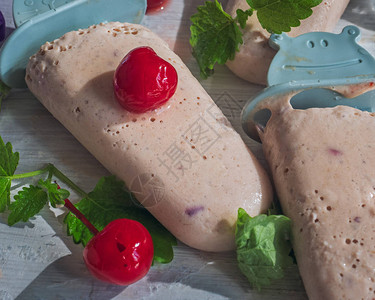 热夏天美味的甜点水果自制冰淇淋和装饰棒上的奶油都放在浅木质背景上图片