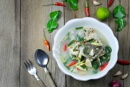 汤姆百胜石斑鱼辣汤在木地板上的碗里放着泰国菜图片