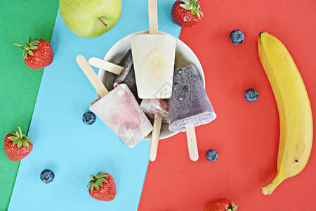 草莓蓝莓苹果和香蕉的自制冰棒图片