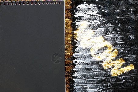黑色亮片背景的金色亮片WOW字母黑布笔记板和填入的图片