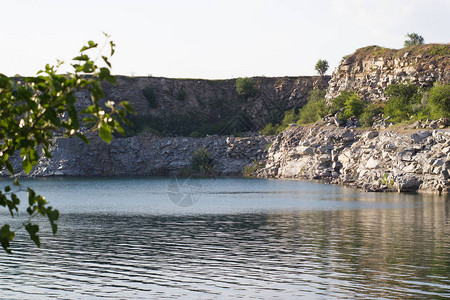 蓝天湖水的大块花岗岩石大理石采场背景图片