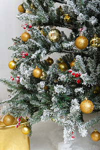 圣诞作文与金球装饰品玩具的圣诞树枝上的白雪树下的大礼物黄金图片