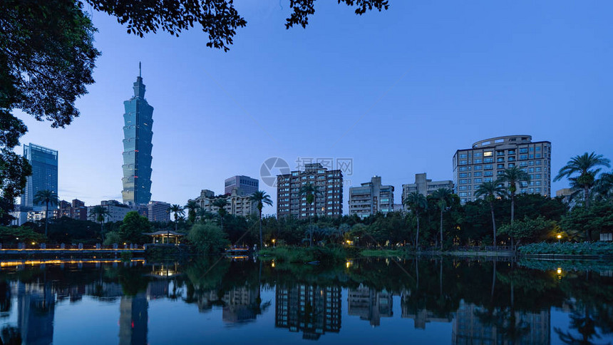 台北公园花和摩天大楼的倒影日出时智能城市的金融图片