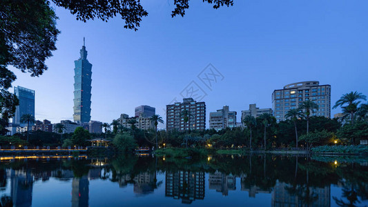 台北公园花和摩天大楼的倒影日出时智能城市的金融图片