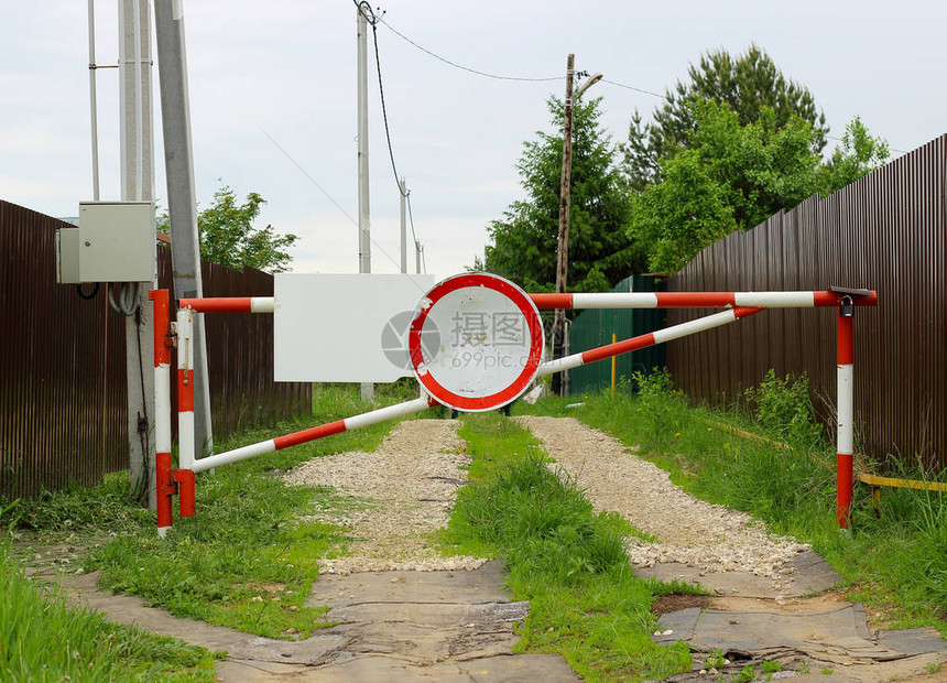 公路上封闭的红白条纹铁栅栏和交通标志图片