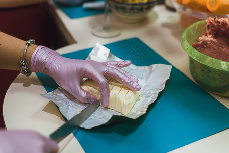 戴手套的女厨正在切黄油做图片