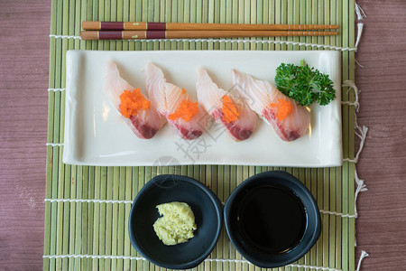 白色盘子上的哈马奇寿司图片