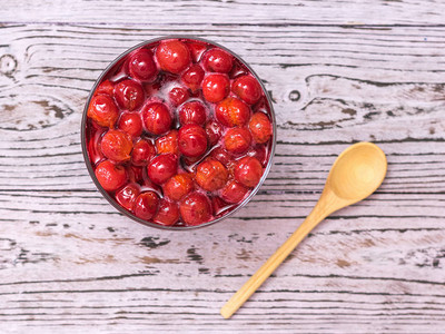 樱桃酱和木勺制的桌子上来自新鲜收获的樱桃浆果的自制果酱从顶部图片