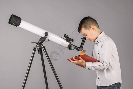 年轻的天文学家透过望远镜寻找并在平图片