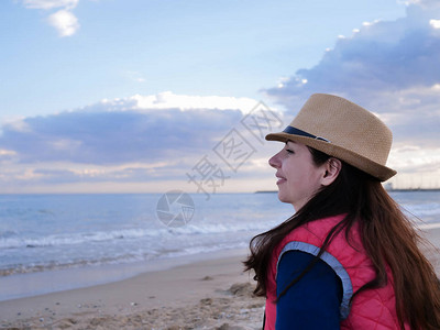 黑发女孩坐在海边的沙滩上图片