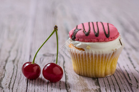 两颗樱桃浆和木桌上的蛋糕甜点图片