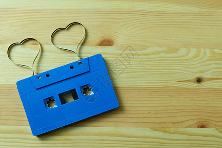 带标签带心形的蓝色盒式磁带音频在木地板上带有复制空间图片