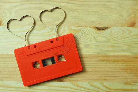 带标签带心形的红色盒式磁带音频在木地板上带有复制空间图片