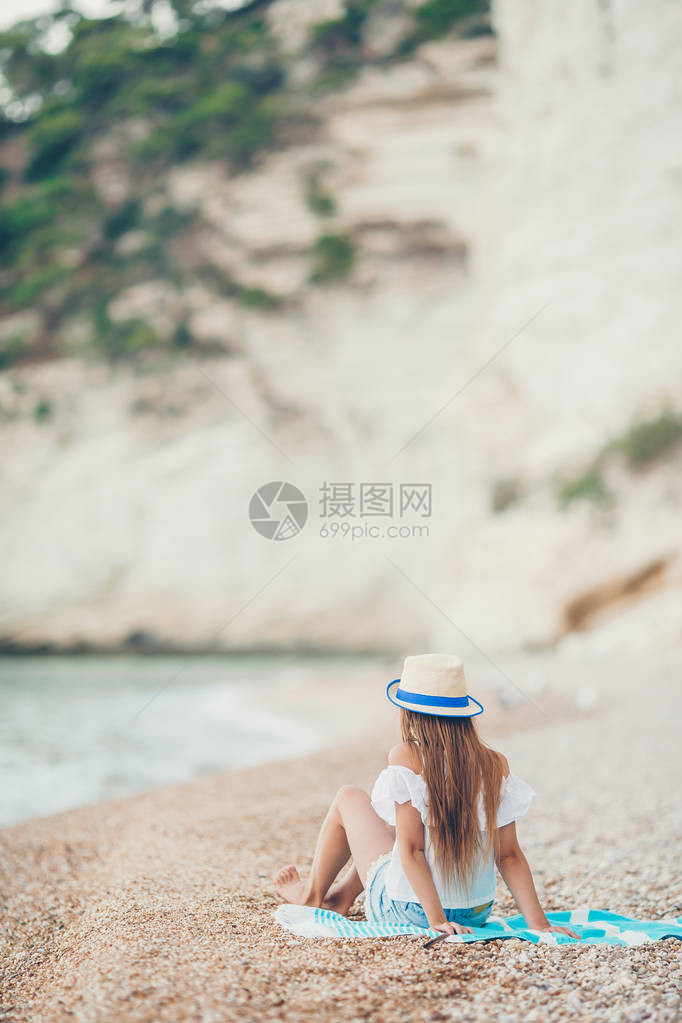 暑假在海滩上戴着草帽的可爱小女孩图片